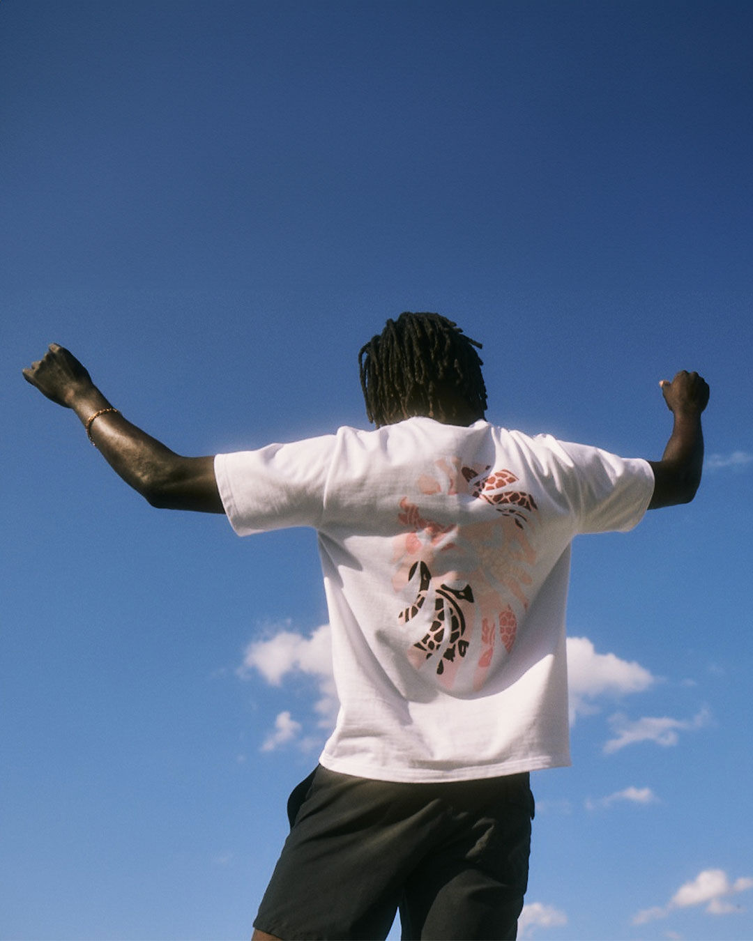 A man seen from behind raising his arms